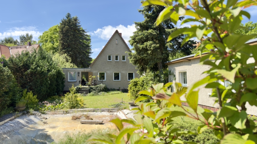 Blick über den Teich auf Bungalow und Haus