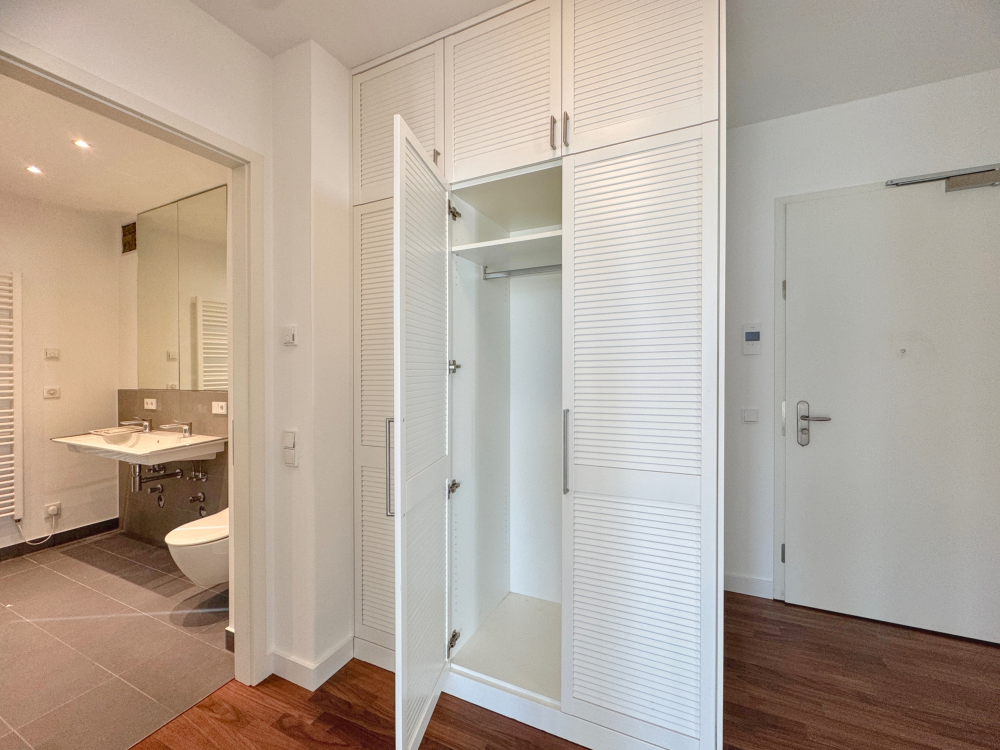 Blick vom Flur mit Einbauschrank zum Bad